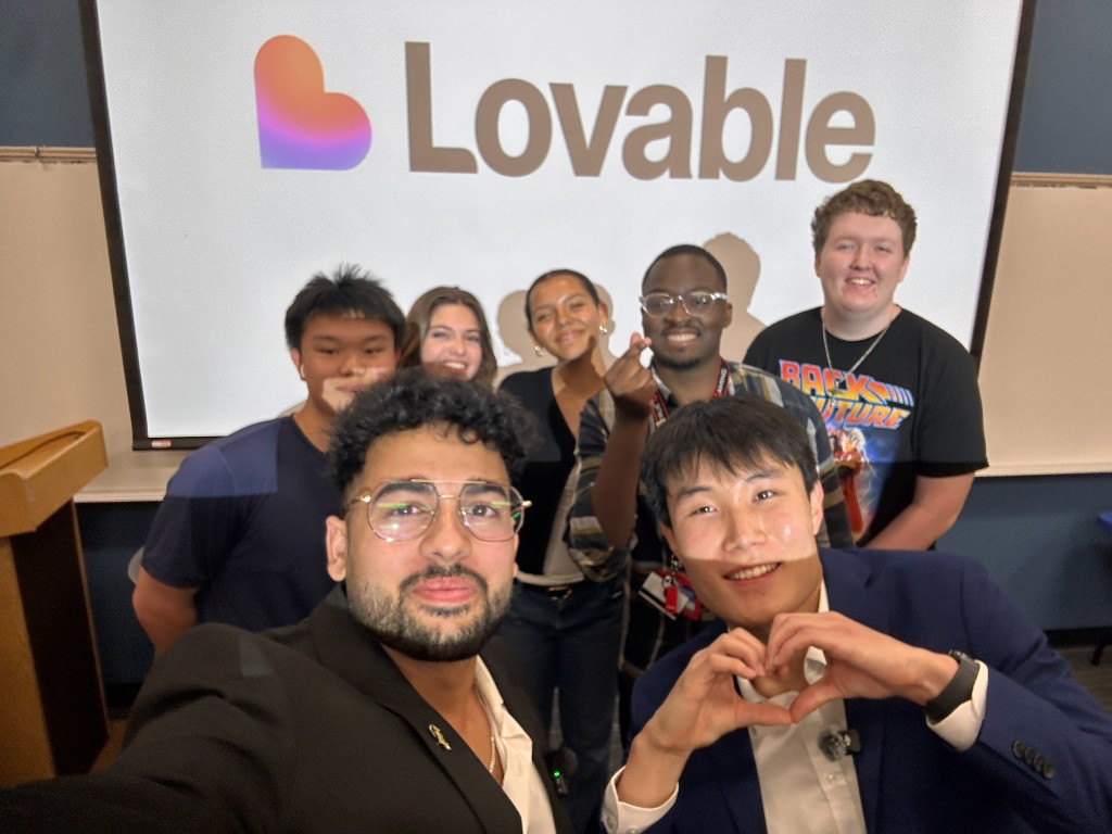 NGF facilitators and students together in front of a Lovable presentation screen after an AI build workshop